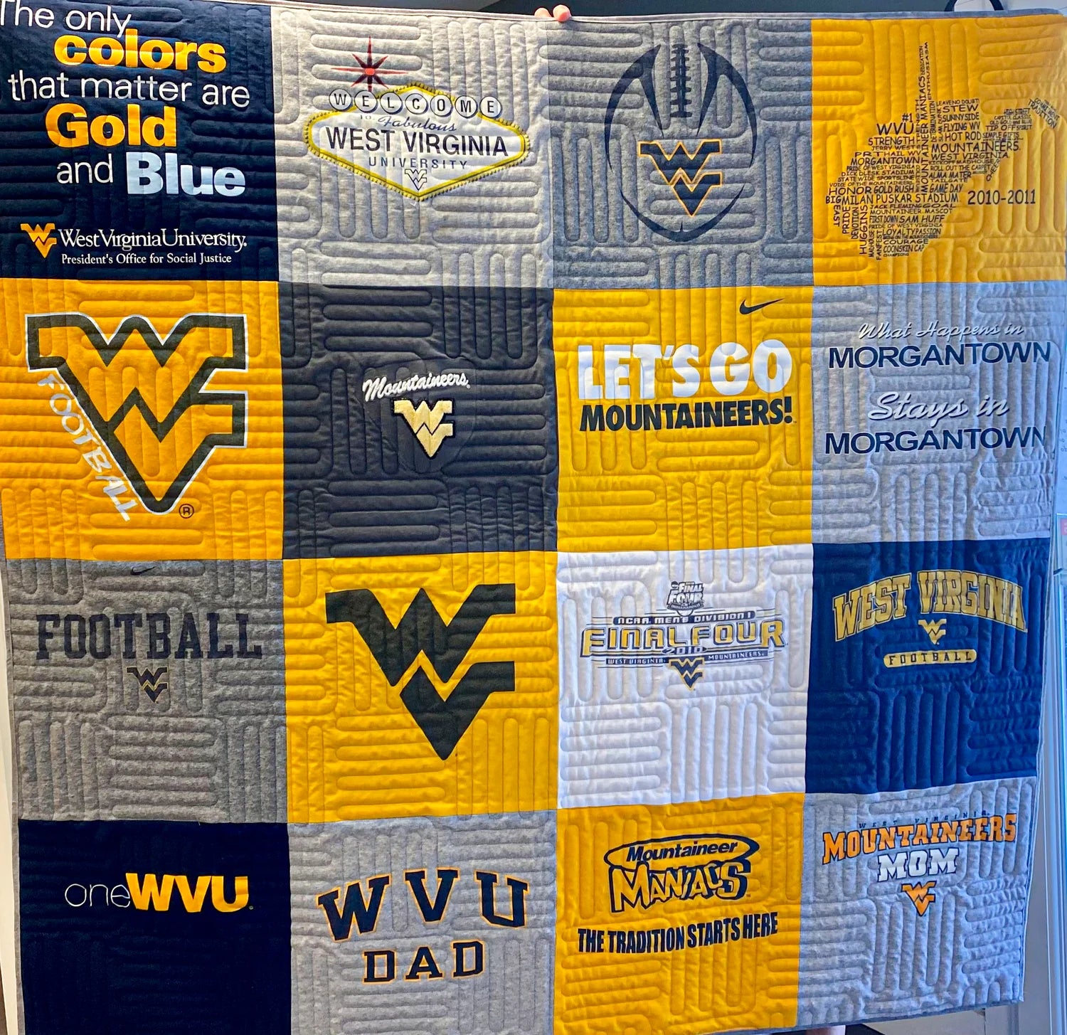 Quilt with West Virginia University logos and text in gold, blue, and gray.